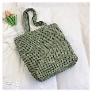 Detail of green woven tote bag showing intricate crochet pattern and soft cotton texture
