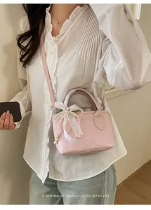 Dettagli della mini borsa a secchiello rosa con fiocco di perle e nastro di raso