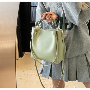 Dettaglio della borsa a secchiello verde chiaro con anelli dorati e pelle PU opaca