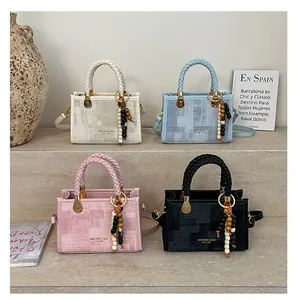 Détails de sacs à bandoulière texturés en crème, bleu et rose avec poignées tressées