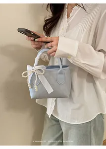 Mini borsa a secchiello azzurra con ciondolo a fiocco di perle e manico in seta