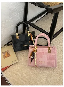 Détail des poignées tressées et des breloques en perles sur sacs noir et rose