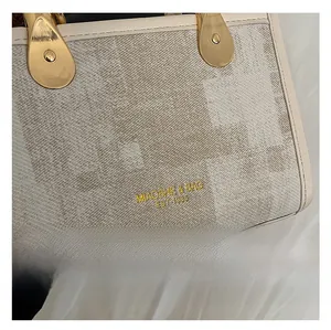 Détails de la texture du tissu et ferrures dorées sur le sac bandoulière café