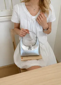 Nahaufnahme der silbernen Halbmond-Handtasche mit metallischer Plisseestruktur