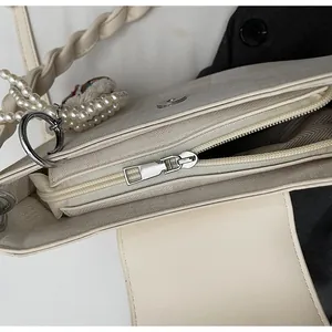Detailed view of cream PU leather bag with metal zipper and woven texture handle