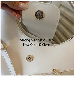 Detail van de magnetische sluiting en ritssluiting op een witte wax lederen schoudertas