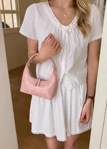 Detail der rosa plissierten Halbmond-Tasche mit glänzender Textur und hobo-förmigem Design