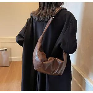 Dettaglio borsa a mezzaluna marrone con pelle plissettata vintage indossata a spalla