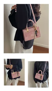Vue détaillée du sac bandoulière en jacquard rose avec poignée tressée et breloque