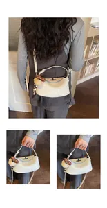Detail einer cremefarbenen Halbmond-Tasche mit süßem Plüschbären und Perlenanhänger
