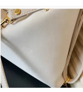 Detailopname van de crèmekleurige oliewas lederen textuur en gouden hardware van de tas