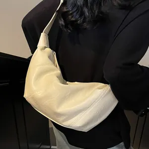 Elegante borsa hobo color crema con trama in pelle pieghettata portata a spalla