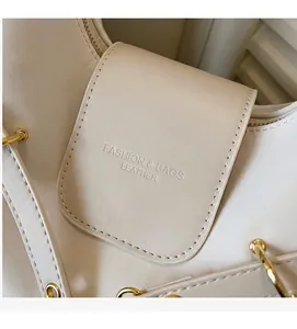 Detail van de crème waslederen tote tas met gouden hardware en mode-reliëflogo