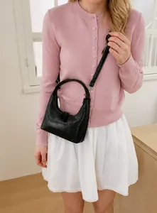 Details einer schwarzen glänzenden Hobo-Tasche mit Faltenoptik und Trageriemen