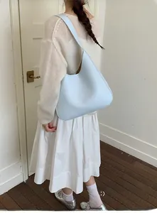 Chic light blue hobo bucket bag in glossy leather shown as a stylish shoulder bag
