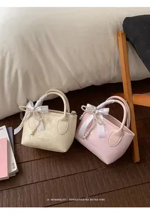 Dettagli di mini borse a secchiello con manici in nastro di seta e perle decorative