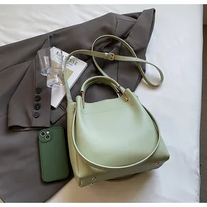Dettaglio borsa a secchiello verde chiaro con pelle PU opaca e dettagli dorati
