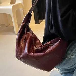 Borsa a tracolla minimalista color bordeaux intenso a forma di croissant con tracolla larga