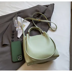 Dettaglio della borsa a secchiello in pelle verde menta con finiture dorate e piedini