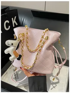 Close-up of pink quilted bucket bag with golden chain and cute pony charm detail
