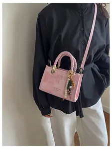 Sac bandoulière rose en toile texturée avec poignées tressées et breloque perlée ethnique