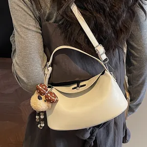 Schicke beige Halbmond-Handtasche mit verstellbarem Riemen und süßem Plüschbär-Anhänger