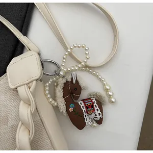 Detailed handmade brown horse bag charm with pearl strap and ethnic floral embroidery