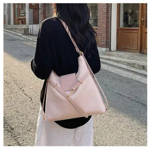 Detail van roze leren tote bag met gouden metalen sluiting en verstelbare riem