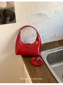 Detailansicht der roten Lackleder-Tasche mit Doppelreißverschluss und stabilem Rundgriff