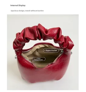 Internal view of the red pleated bag showing the zipper pocket and main compartment