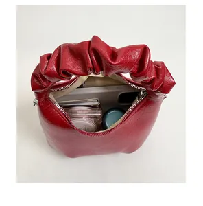 Top view of red pleated handbag interior showing capacity for makeup and smartphone