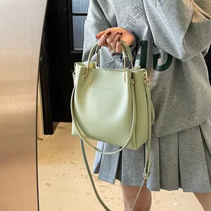 Secchiello verde chiaro chic con manico ad anello in metallo e tracolla da donna