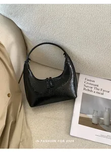 Detail der schwarzen Lackleder-Hobo-Tasche mit Faltenstruktur und Doppelreißverschluss