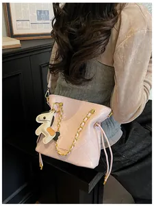 Detail of pink quilted bucket bag with gold chain and cute horse leather charm