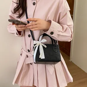 Elegante mini borsa a secchiello nera con fiocco di seta bianco e ciondoli di perle