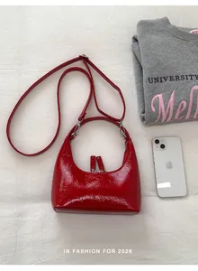 Details der roten Crescent Bag aus glänzendem Lackleder mit Doppelreißverschluss