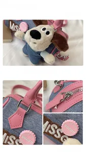 Detailed view of denim and pink leather Boston bag with plush puppy and metal zipper