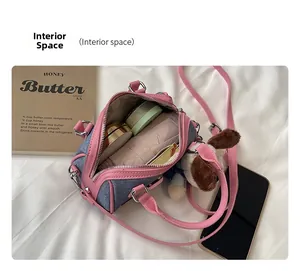 Interior space of a pink and denim Boston bag showing daily items and plush puppy charm