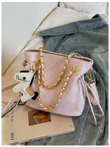 Detail of pink quilted bucket bag with chain strap and a decorative horse charm