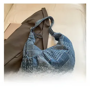 Detailed patchwork denim hobo bag featuring various blue fabrics and drawstring details