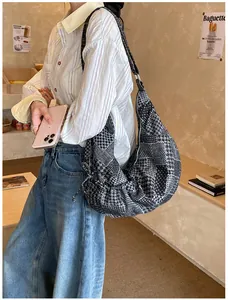 Detail of a large patchwork hobo bag featuring houndstooth and polka dot patterns