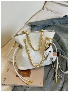 Close-up of white quilted leather bucket bag with gold chain and horse charm detail