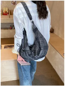 Detail of patchwork denim tote bag with houndstooth and polka dot patterns on a model