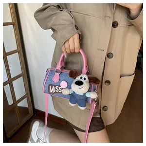 Blue denim Boston bag with pink leather straps and a cute plush dog pendant detail