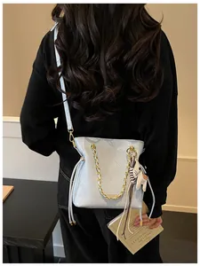 Light blue quilted bucket bag with gold chain and pony charm shown on a model