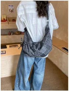 Lifestyle shot showing the large patchwork denim crossbody bag with unique geometric patterns