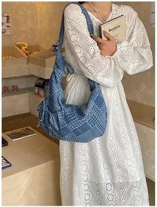 Detail of blue patchwork denim hobo bag featuring checkered patterns and large capacity