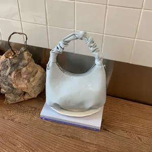 Detail of light blue pleated handbag with glossy texture and ASDE & BAGS logo branding