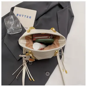 Internal view of quilted bucket bag with chain strap showing storage for phone and wallet