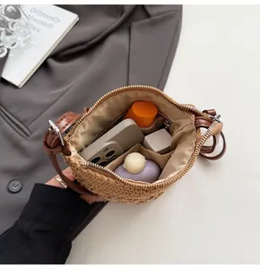 Détail intérieur du sac en paille montrant les compartiments, la doublure et la capacité